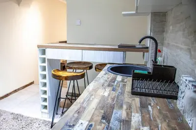a kitchen with a wooden counter with stools under it at Colorway Apartment in Belgrade