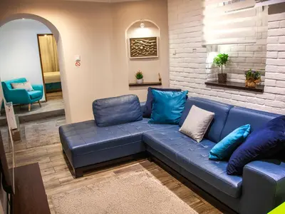 a blue couch in a living room with blue pillows at Colorway Apartment in Belgrade