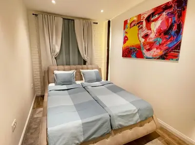 a bedroom with a bed and a painting on the wall at Colorway Apartment in Belgrade