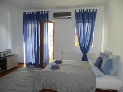 a bedroom with a bed with a teddy bear on it at Blue Apartment in Belgrade