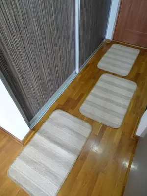 three white rugs on the floor of a room at Blue Apartment in Belgrade