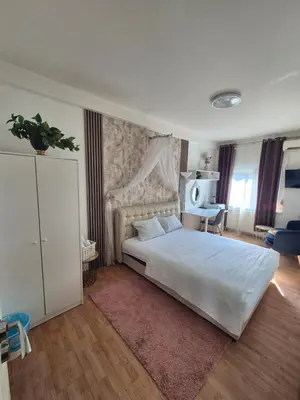 a bedroom with a large white bed in a room at Rooms Villa Luigi in Pančevo