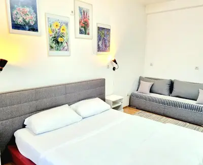 a bedroom with a bed and a couch at Rooms Villa Luigi in Pančevo