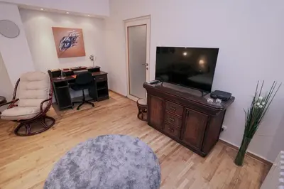 a living room with a television and a desk with a chair at Ratan in Belgrade
