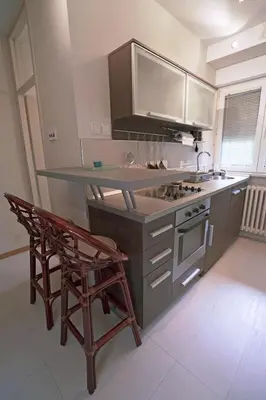 a kitchen with a counter and a stove and two chairs at Ratan in Belgrade