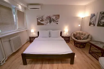 a bedroom with a bed and a couch and a chair at Ratan in Belgrade