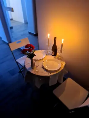 a table with two candles and a bottle of wine at TASOS in Belgrade