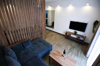 a living room with a blue couch and a table at TASOS in Belgrade