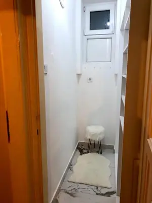 a small hallway with a stool and a window at 1BR Flat in Heart Of Belgrade With Panoramic Central View in Belgrade