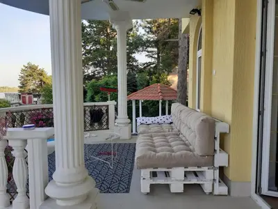 a porch with white columns and an umbrella at Prenociste Dunav 97 K3 in Novi Banovci