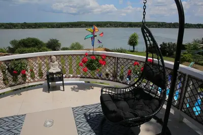 a swing on a balcony with a view of the water at Prenociste Dunav 97 K5 in Novi Banovci