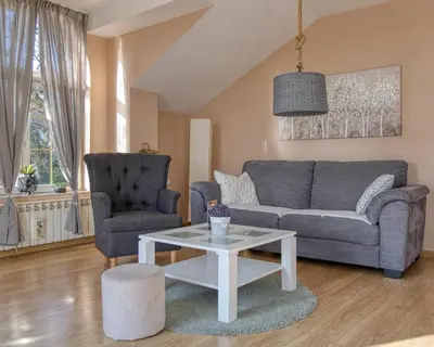 a living room with a couch and a table and two chairs at Prenociste Dunav 97 K5 in Novi Banovci