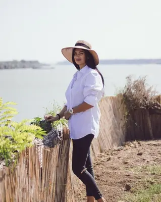 a woman wearing a hat standing next to a fence at Prenociste Dunav 97 K6 in Novi Banovci