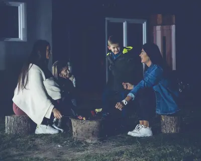 a group of people sitting around a fire at Prenociste Dunav 97 K6 in Novi Banovci