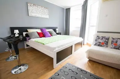 a bedroom with a white bed and a couch at Maxim in Belgrade