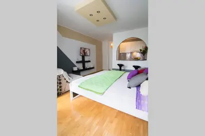 a bedroom with a large white bed with pillows at Maxim in Belgrade