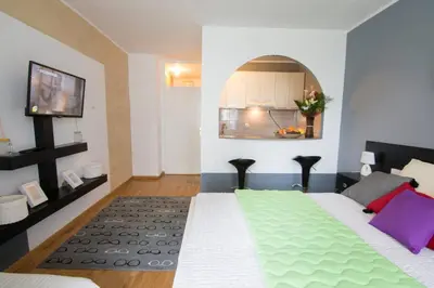 a bedroom with a large bed with a green blanket at Maxim in Belgrade