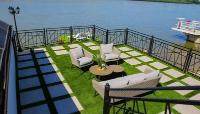 a balcony with chairs and a table and the water at Harmonija na Dunavu in Smederevo