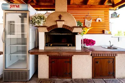a outdoor kitchen with a pizza oven and a sink at Harmonija na Dunavu in Smederevo