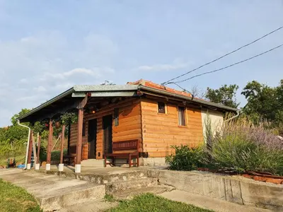 a small wooden house with a porch on a hill at Vajat Orašac in Arandjelovac