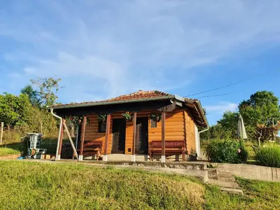 a small wooden house with a porch on a field at Vajat Orašac in Arandjelovac