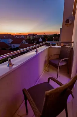 a balcony with two chairs and a view of a city at White Apartments in Belgrade
