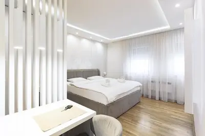 a bedroom with two beds and a table and chairs at White Apartments in Belgrade