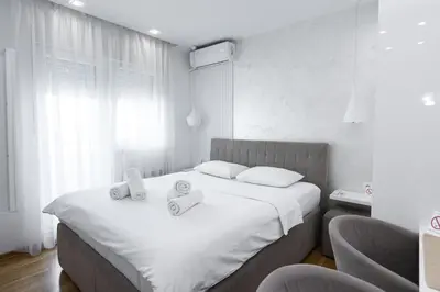 a bedroom with a bed with two towels on it at White Apartments in Belgrade