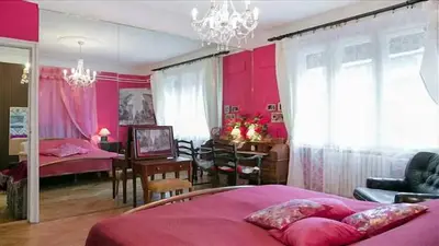 a bedroom with a pink bed and a dining room at FABOULOUS apartment in Belgrade