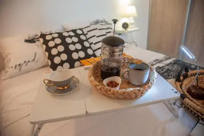 a coffee table with two cups and a tray on a bed at Sensational view - Zemun in Belgrade