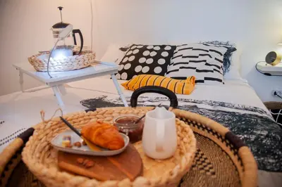 a room with a table with a tray of food on a bed at Sensational view - Zemun in Belgrade
