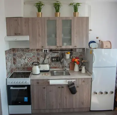 a kitchen with wooden cabinets and a white refrigerator at Sensational view - Zemun in Belgrade