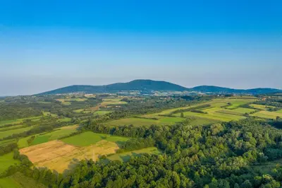 an aerial view of a field with trees and mountains at Kosmaj Casa Maia in Dučina