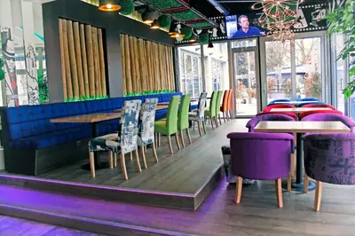 a restaurant with purple and green chairs and tables at ESTRADA Lux in Belgrade