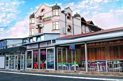a store front of a pink building with tables at ESTRADA Lux in Belgrade