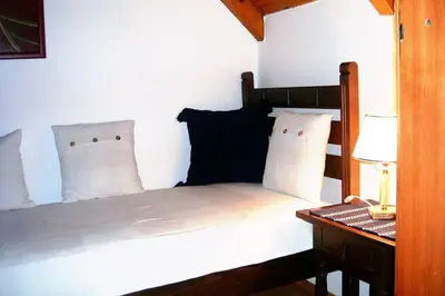 a bed with white pillows and a desk with a lamp at Villa Kornelija in Stari Slankamen