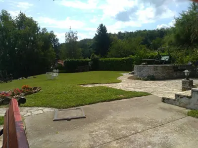 a backyard with a lawn and a garden with a fence at Villa Kornelija in Stari Slankamen