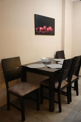 a dining room table with four chairs and a painting at Goliath in Belgrade