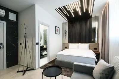 a bedroom with a bed and a couch at The Location Hotel in Belgrade