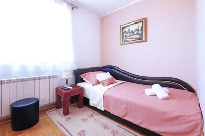 a bedroom with two beds with pink and white sheets at Villa Tower Gardos in Belgrade