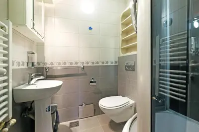 a small bathroom with a toilet and a sink at Villa Tower Gardos in Belgrade