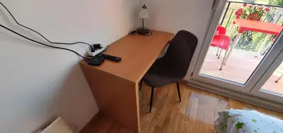 a desk with a chair in a room with a window at Julija in Pančevo