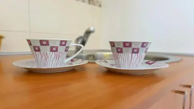 two coffee cups sitting on a wooden table at Nilena apartmani in Smederevo