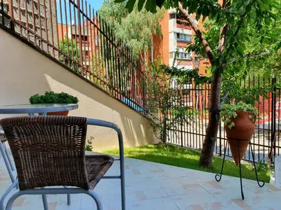 a chair and a table and a tree on a patio at Nilena apartmani in Smederevo