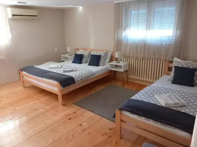a bedroom with two beds and a window at Apartman Talija in Arandjelovac