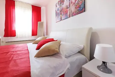 a bedroom with a bed with red and white pillows at Apartment Paradise Fantasy in Belgrade
