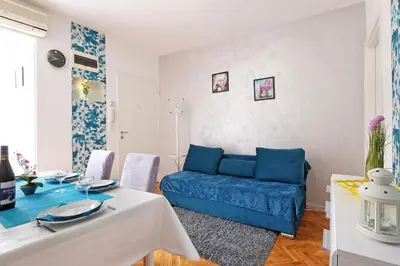 a living room with a blue couch and a table at Apartment Paradise Fantasy in Belgrade