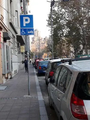 a parking sign on the side of a street with parked cars at Apartment Paradise Fantasy in Belgrade