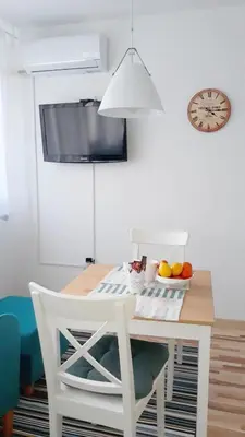 a dining room table with a white chair and a clock at BLUE DANUBE in Belgrade