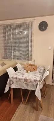a dining room table with chairs and a clock on the wall at Vinogradski konak Belgrade, Sopot,Kosmaj in Sopot